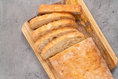 Gri masada taze pişmiş ciabatta ekmeği dilimlenmiş somun..
