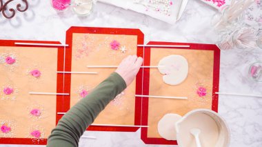 Düz yatıyordu. Ev yapımı lolipoplar yapmak için silikon paspaslara karamelize şeker dökmek..