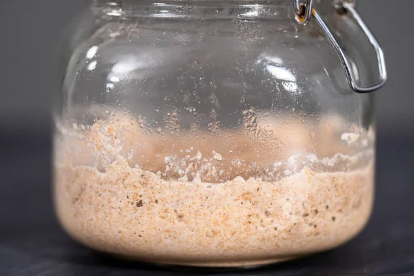 Homemade wheat sourdough starter in a glass mason jar.