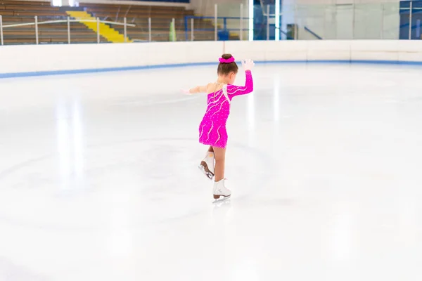 Pembe Elbiseli Küçük Artistik Patinajcı Kapalı Buz Pistinde Pratik Yapıyor — Stok fotoğraf