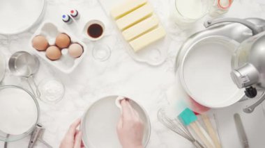 Adım adım. Düz yatıyordu. Üç katlı vanilyalı kek pişirmek için tereyağlı kek tavaları yağlamak..