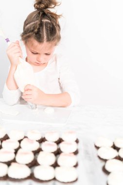 Küçük kız İtalyan tereyağı kreması tatlandırması yapıyor..