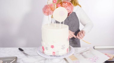 Süslenmek için uzun beyaz yuvarlak pastanın içine kar taneli büyük lolipoplar yerleştiriyoruz..