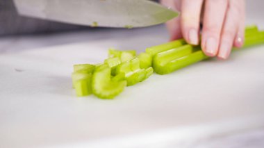 Vejetaryen fasulye çorbası pişirmek için sebzeleri doğramak..