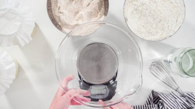 Düz yatıyordu. Tarçınlı rulo pişirmek için cam bir kasenin içindekileri ölçüyorum..