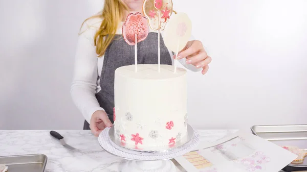 Inserting Large Lollipops Snowflakes Tall White Cake Final Decoration — Stock Photo, Image