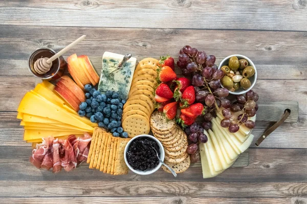 Flat Lay Gourmet Cheese Crackers Fruit Wood Cutting Board Served — Stock Photo, Image