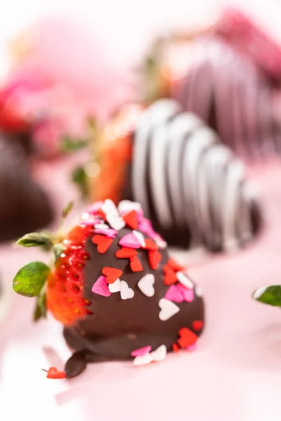 ピンクの背景に様々なチョコレートがイチゴを浸した — ストック写真