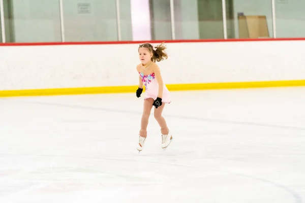 Kleines Mädchen Übt Eiskunstlauf Auf Einer Überdachten Eisbahn — Stockfoto