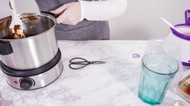 Adım adım. Çikolata parçacıkları eriyen kaplarda eriyor..