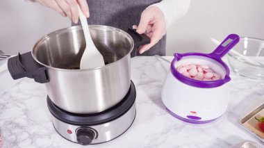 Adım adım. Çikolata parçacıkları eriyen kaplarda eriyor..