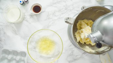 Adım adım. Düz yatıyordu. Üç katlı vanilyalı kek pişirmek için mutfak mikserinin malzemelerini karıştırıyorum..