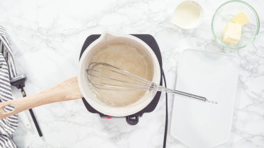 Düz yatıyordu. Adım adım. Pişirme kabında ev yapımı karamel hazırlanıyor.