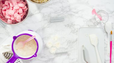 Düz yatıyordu. Adım adım. Erimiş çikolatayı kar taneleri şeklinde plastik bir çikolata kalıbına döküyorum..