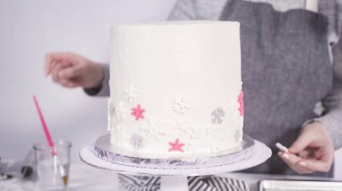 Adım adım. Yuvarlak funfetti pastasını pembe ve beyaz fondant kar taneleriyle süslüyorum..