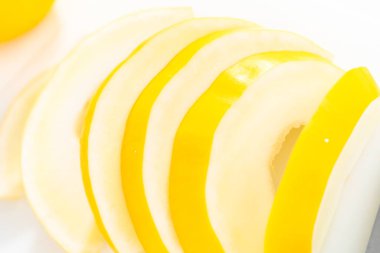 Beyaz kesme tahtasında kaygan altın çiğ taneli kavun.