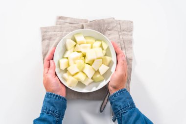 Düz yatıyordu. Beyaz bir kasede dilimlenmiş altın çiğ taneli kavun..