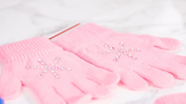 Rhinestone pink kids gloves with snowflake shapes.