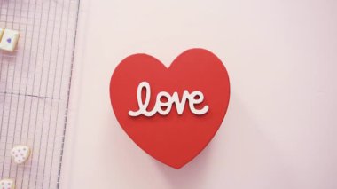  Pembe arka planda kalp şeklinde kurabiyeler olan kutu 