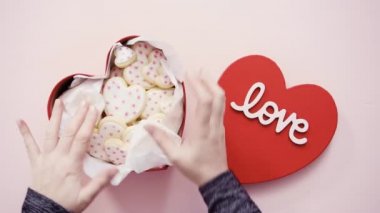  Pembe arka planda kalp şeklinde kurabiyeler olan kutu 