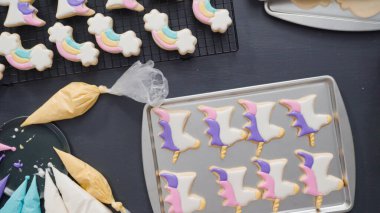 Adım adım. Düz yatıyordu. Tek boynuzlu at şekerli kurabiyelerin üzerine kraliyet kreması süslemek..