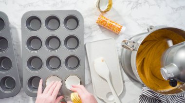 Düz yatıyordu. Balkabağı aromalı kek hamuru. Hamur hamuru kepçesiyle kapkek tepsisine dolgu malzemesi..