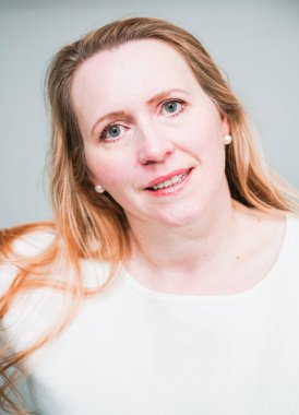 Gülümseyen orta yaşlı kadının stüdyo portresi.