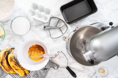 Düz yatıyordu. Muzlu fındıklı ekmek pişirmek için mutfak mikserinde malzemeler karıştırılıyor..