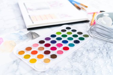 Baker küçük bir kızın doğum günü partisi için doğum günü pastası tasarlıyor..