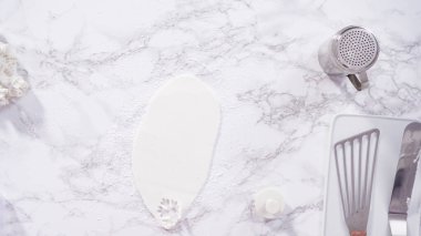 Düz yatıyordu. Adım adım. Mermer tezgahın üzerindeki beyaz fondanla kar tanelerini keserek..