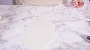 Adım adım. Beyaz fondantımızı mermer tezgahta yuvarlıyoruz..