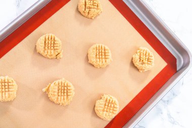 Fıstık ezmeli kurabiye hamurunu silikon paspasların üzerine koymak..