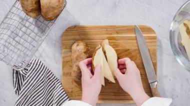 Düz yatıyordu. Adım adım. Fırında pişirmek için zeytinyağı ve baharatla patates dilimliyorum..