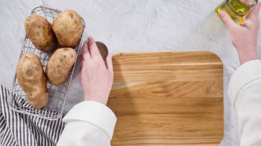 Düz yatıyordu. Adım adım. Fırında pişirmek için zeytinyağı ve baharatla patates dilimliyorum..