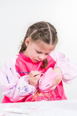 COVID-19 tecridi sırasında evde eğitim. Kağıt mache boyalı küçük kız Akrilik boyalı Paskalya tavşanı biblosu.