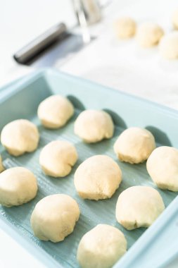 Beyaz bir tezgahın üzerinde mayalı hamurla yemek pişiriyorum..