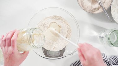 Düz yatıyordu. Tarçınlı rulo pişirmek için cam bir kasenin içindekileri ölçüyorum..