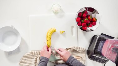 Düz yatıyordu. Mutfak blendırında çilekli ve muzlu smoothie hazırlıyorum..