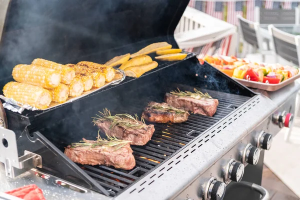 Grillowanie Nowojorskiego Steku Kawałkiem Masła Rozmarynu Grillu Gazowym Świeżym Powietrzu — Zdjęcie stockowe