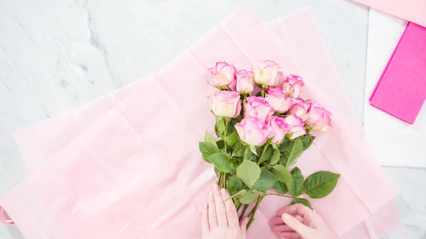 平置きだ 一歩ずつ ピンクのバラから花束を手配する花屋 — ストック写真