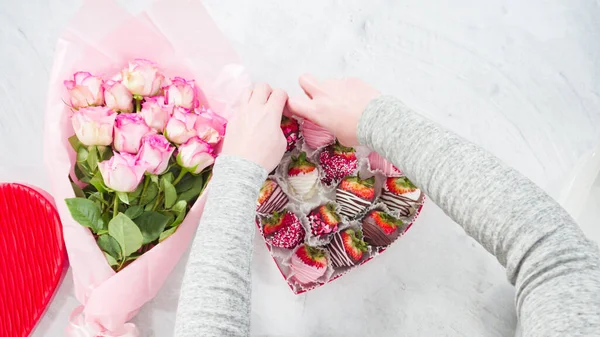 平置きだ 一歩ずつ ピンクのバラの花束とチョコレートの箱がイチゴを浸した — ストック写真