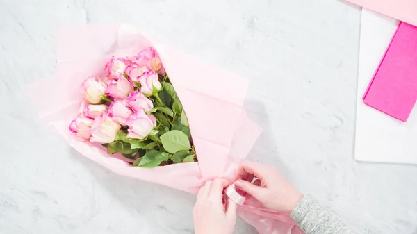 平置きだ 一歩ずつ ピンクのバラから花束を手配する花屋 — ストック写真