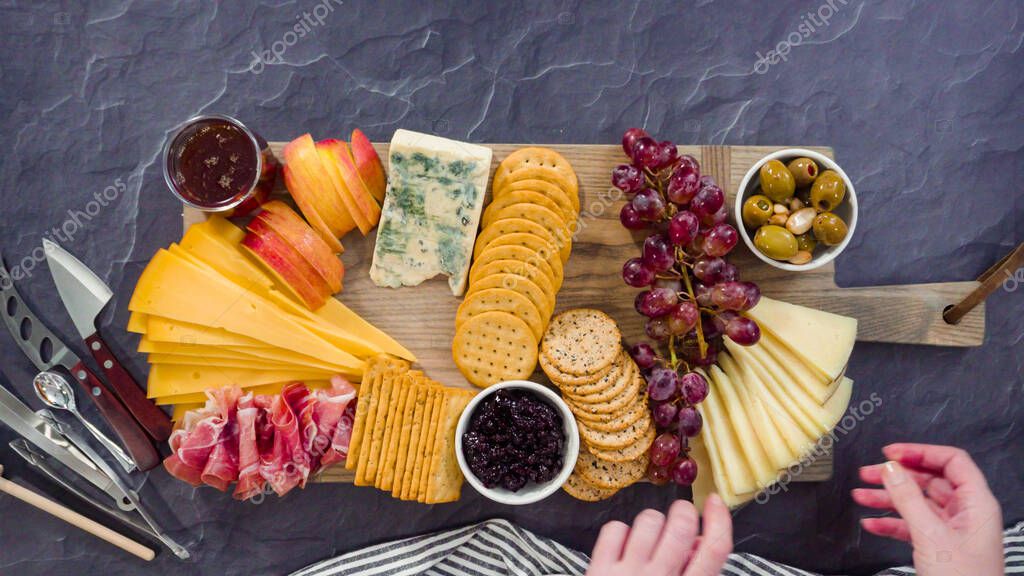 Acostado. Organizar queso gourmet, galletas y frutas en una tabla para