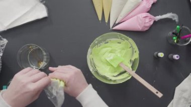 Adım adım. Düz yatıyordu. Şekerli kurabiyeleri süslemek için kraliyet kremasına gıda boyası karıştırmak..