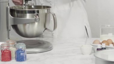 Adım adım. Düz yatıyordu. Kırmızı, beyaz ve mavi fırıldak şekerli kurabiyeler pişirmek için kurabiye hamuruna gıda boyası karıştırıyorum..