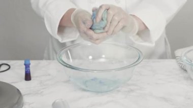 Adım adım. Düz yatıyordu. Kırmızı, beyaz ve mavi fırıldak şekerli kurabiyeler pişirmek için kurabiye hamuruna gıda boyası karıştırıyorum..