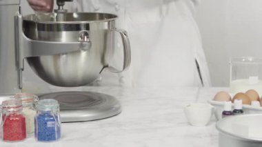 Adım adım. Düz yatıyordu. Kırmızı, beyaz ve mavi fırıldak şekerli kurabiyeler pişirmek için kurabiye hamuruna gıda boyası karıştırıyorum..