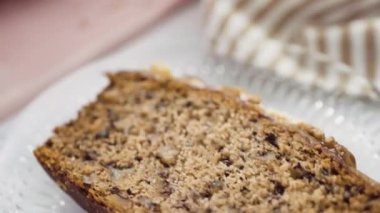 Taze pişmiş muzlu fındıklı ekmek, ev yapımı karamelli pembe kesim tahtasının üzerinde..