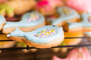 Farklı renklerde kraliyet kremalarıyla süslenmiş Paskalya şekerli kurabiyeler..