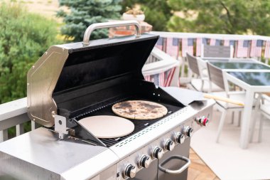 Açık hava gaz ızgarasında pizza taşları ısıtılıyor..